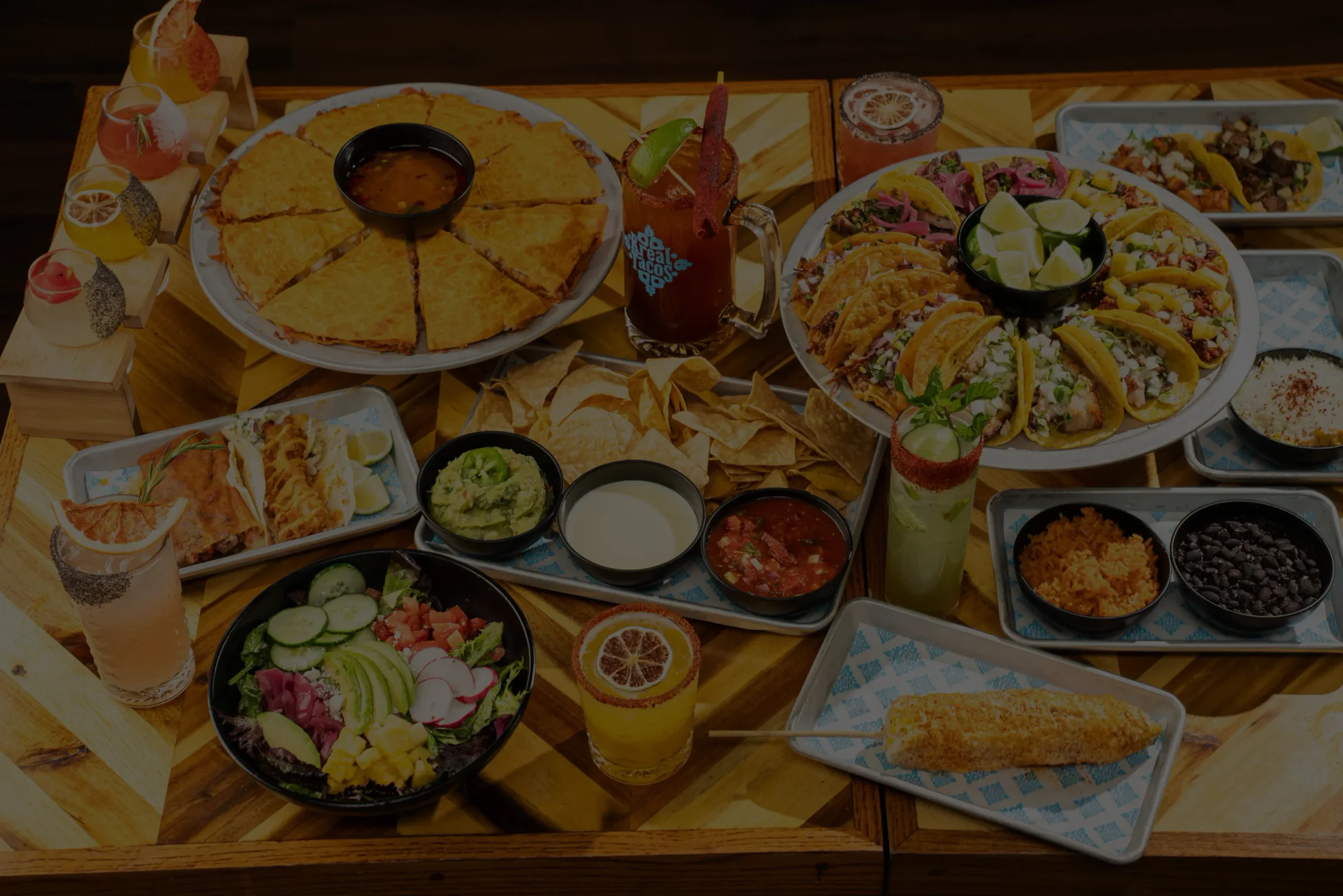 Rreal Tacos spread — quesadillas, tacos, chips, guacamole, sides and drinks