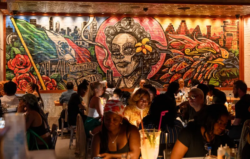 Rreal Tacos restaurant interior with a vibrant Day of the Dead mural